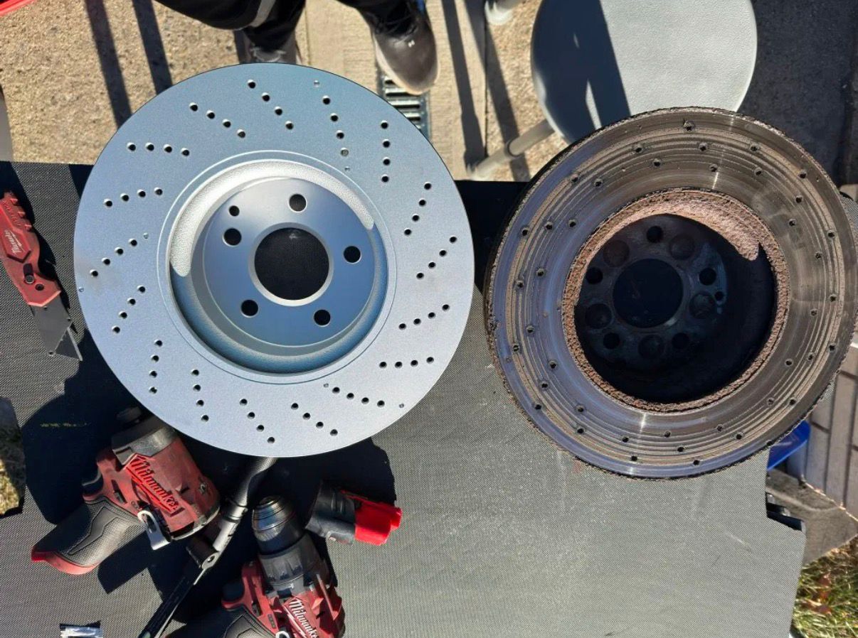 New drilled brake rotor next to a worn rotor